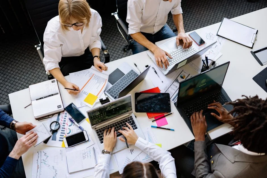 Une personne en train de taper sur un ordinateur portable dans un bureau lumineux et moderne, illustrant la productivité et la technologie.